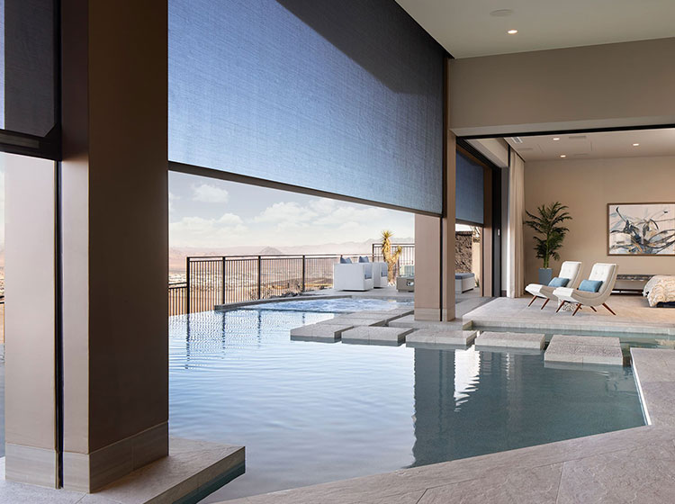 Indoor-outdoor pool with motorized screens and desert mountain views
