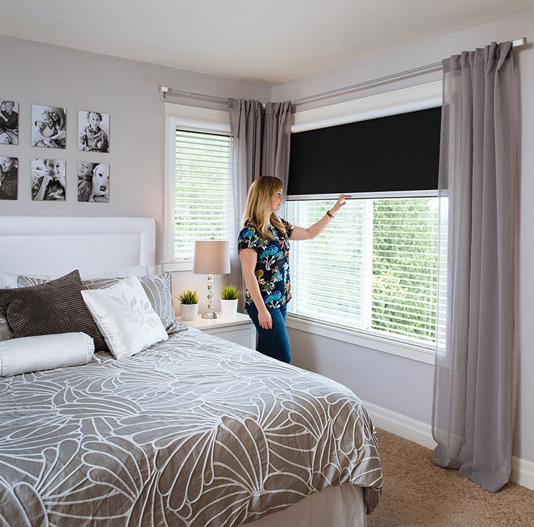 Modern bedroom with retractable window screen, gray curtains, and decorative photo wall display